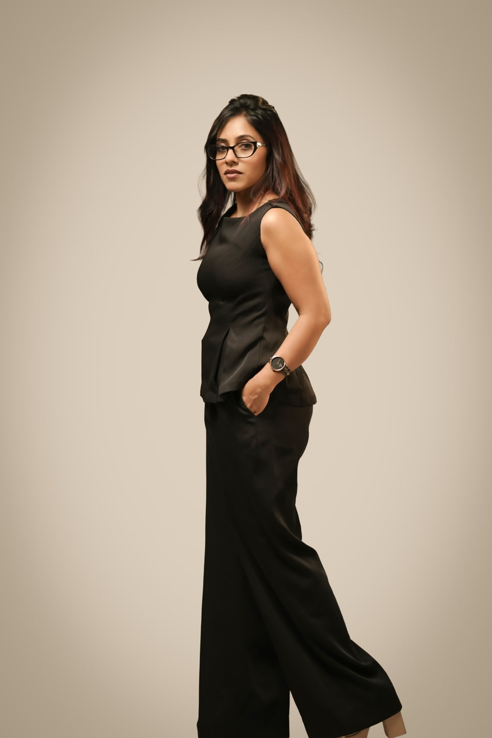 Black peplum co-ord set with sculpted waist and wide-leg trousers, front view — Ikigara