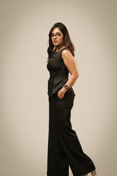 Black peplum co-ord set with sculpted waist and wide-leg trousers, front view — Ikigara